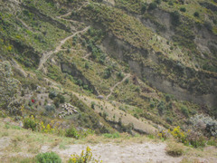 Shepherd (tiny red dot) on the slopes leading down to lake Quilotoa.