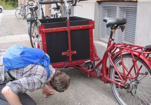 Visiting Copenhagen is like visiting a bicycle zoo: there is an example of every species, including a lot of utility bikes.  Here, Joe studies the steering system of a Christiania bike.
