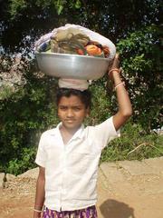 Indian girl carrying laundry on her head, Hampi.