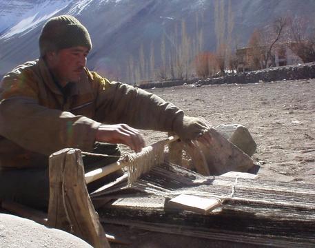 Ladakhi man weaving a woolen mat in the town of Alchi.
