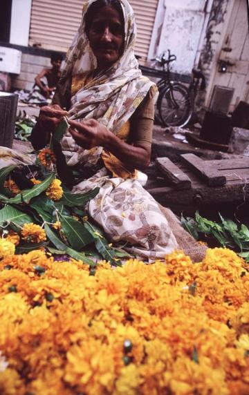 Woman selling strings of marigolds for Diwali.