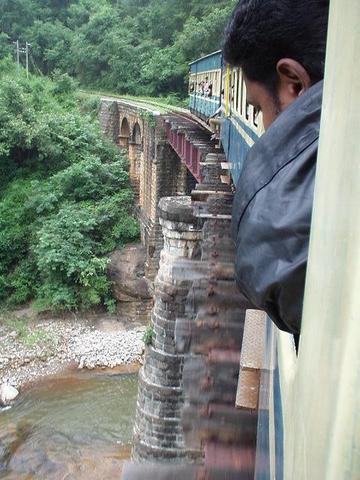 Indian man looking out the winow of the Ooty train.