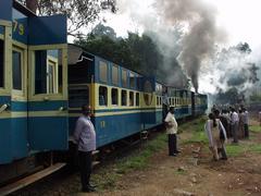 People waiting outside of the Ooty train at a watering stop.