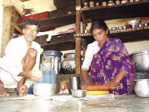 Toda village elder, named Onir Katan, preparing dinner for us with another Toda woman.