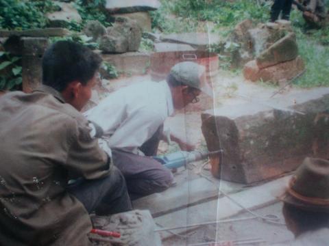 Camodians reinforcing blocks of one of the Angkor ruins.